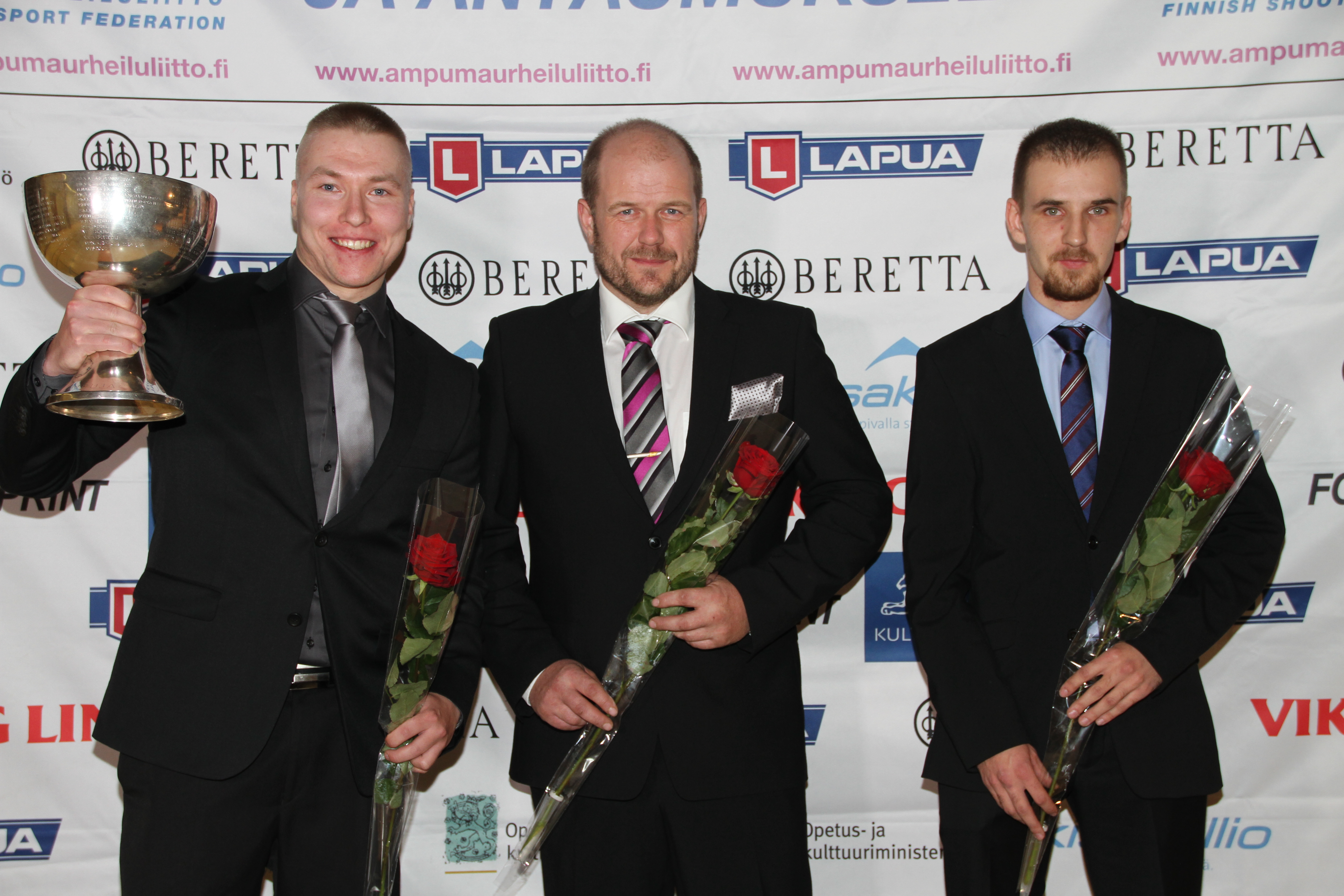 Tomi-Pekka Heikkilä (vas.), Krister Holmberg ja Heikki Lähdekorpi ja Vuoden ampumaurheilija -pokaali. (Kuvat; Lassi Palo)